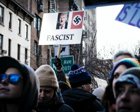 shallow focus photo of person holding Donald Trump signage