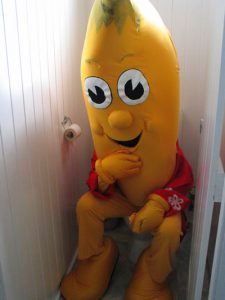 person dressed as banana sitting on the toilet